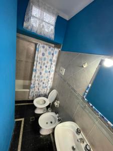 Un baño con dos inodoros y un lavabo. en Departamento en Miramar, en Miramar
