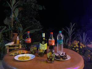 a table with bottles of alcohol and plates of food at Shangdhan Pine Homestay in Sāmthar
