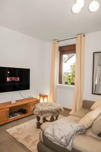 a living room with a couch and a tv at Helle geräumige 80 qm Wohnung - 5 min von Friedberg - Self Check-In in Bruchenbrücken