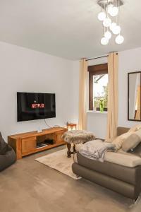 a living room with a couch and a flat screen tv at Helle geräumige 80 qm Wohnung - 5 min von Friedberg - Self Check-In in Bruchenbrücken +33 photos