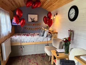 a bedroom with a bed with red heart balloons at Oakies Farm Stays in Llandovery