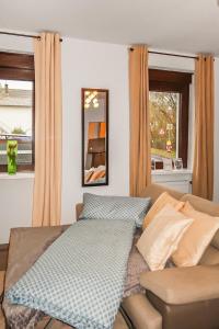 a bed in a room with a couch and a window at Helle geräumige 80 qm Wohnung - 5 min von Friedberg - Self Check-In in Bruchenbrücken