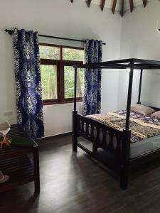 a bedroom with a bed with blue curtains and a window at Villa Sukka in Tangalle +33 photos