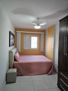 a bedroom with a bed and a window at Apartamento frente mar pé na areia in Praia Grande
