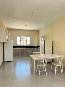 a kitchen with a table and chairs and a refrigerator at Espaço Bella Ville in Americana +7 photos