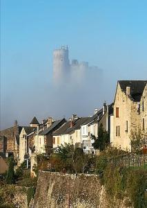 a city with houses and a castle in the background at Roulotte in Ginals