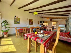 eine Küche und ein Esszimmer mit Tisch und Stühlen in der Unterkunft Inka Pacha Ecohostel in Comunidad Yumani
