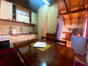 a kitchen with a wooden table and a kitchen with a refrigerator at Apartman Zlatarske Čari in Nova Varoš