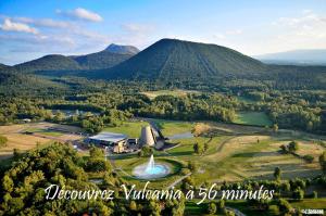 an aerial view of a farm with a fountain and mountains at L'atelier de Mathieu meublés de tourisme classés in Saint-Rémy-sur-Durolle