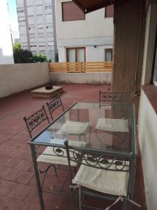 a glass table and chairs on a patio at Mardel REBAJADO living 1 dorm, 4 pers, gran terraza mzn peatonal in Mar del Plata