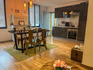 eine Küche und ein Esszimmer mit Tisch und Stühlen in der Unterkunft La Suite du Triomphe - Bain Balnéothérapie,Netflix in Montpellier