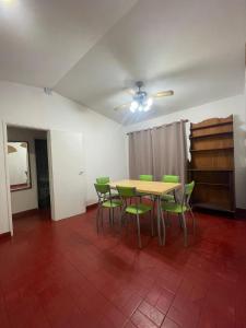 a dining room with a table and green chairs at Casa a 1 cuadra del Río San Antonio in San Antonio de Arredondo