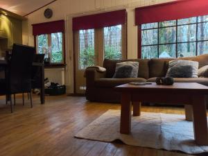 een woonkamer met een bank en een tafel bij Chalet Bosrust in Lanaken