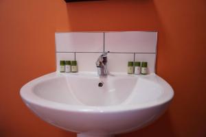 Baño con lavabo blanco y pared de color naranja en Unique 3Bed Home Free Parking Near Meadowhall, en Brightside 34 fotos más