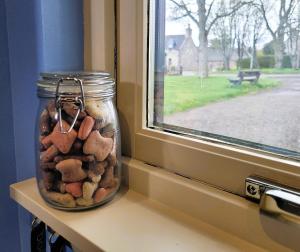 a jar filled with rocks sitting on a window sill at Bespoke Luxury Self Catering Dog Friendly Accommodation in Archiestown