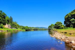 a river with a bridge in the background at Luxury Speyside Hideaway, Dog Friendly, Malt Whisky Trail, Village Green in Archiestown