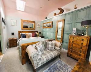 a bedroom with a bed and a couch at Luxury Speyside Hideaway, Dog Friendly, Malt Whisky Trail, Village Green in Archiestown