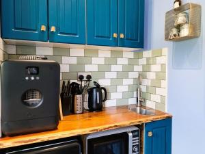 a kitchen counter with blue cabinets and a sink at Luxury Speyside Hideaway, Dog Friendly, Malt Whisky Trail, Village Green in Archiestown