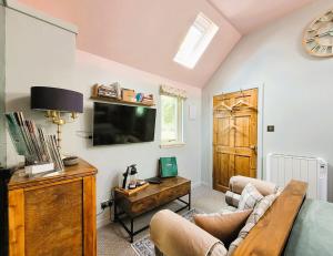 a living room with a couch and a tv at Luxury Speyside Hideaway, Dog Friendly, Malt Whisky Trail, Village Green in Archiestown