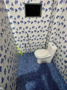 bagno con servizi igienici e piastrelle bianche e blu di Mini Sweet Haven a Digboi