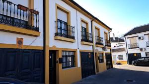 a building with black doors and balconies on a street at LaCasa DeLola in Almodóvar del Río