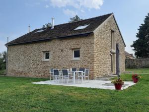 a brick building with a table and chairs in front of it at Celon Nous - La Porcherie in Célon
