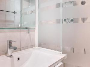a white bathroom with a sink and a shower at Appartement skieurs, accès direct pistes, balcon sud, proche remontées - FR-1-518-109 in Val dʼIsère +9 photos