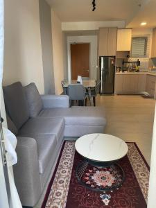 a living room with a couch and a table and a kitchen at RaaNest, Sunsuria Forum in Shah Alam +1 photo