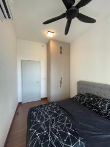 a bedroom with a bed and a ceiling fan at RaaNest, Sunsuria Forum in Shah Alam +1 photo
