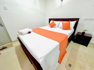 two beds with orange and white sheets in a room at Angel Villa Unakuruwa Tangalle in Tangalle