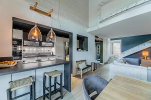 eine Küche und ein Wohnzimmer mit Tisch und Stühlen in der Unterkunft Villa 10pers avec piscine privée in Lacanau