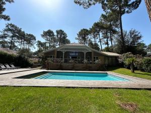 ein Haus mit einem Swimmingpool im Hof in der Unterkunft Villa 10pers avec piscine privée in Lacanau