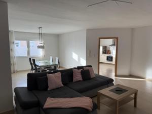 a living room with a black couch and a table at Ferienwohnung Benjamin in Clausen