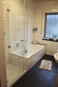 une salle de bain avec une douche, une baignoire et un lavabo dans l'établissement Ferienhaus MeinWeg, à Wassenberg