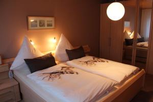 une chambre avec un grand lit avec des draps blancs dans l'établissement Ferienhaus MeinWeg, à Wassenberg