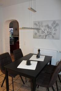 une salle à manger avec une table et des chaises noires dans l'établissement Ferienhaus MeinWeg, à Wassenberg