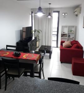 ein Wohnzimmer mit einem roten Sofa und einem Tisch in der Unterkunft Dos Nogales 26 in Villa Carlos Paz