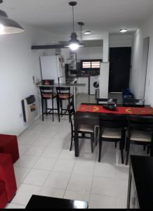 eine Küche und ein Esszimmer mit Tisch und Stühlen in der Unterkunft Dos Nogales 26 in Villa Carlos Paz