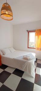 una camera bianca con un letto e un pavimento a scacchi di VV- Badana Stay II - Vive el Atlántico desde el corazón de Tazacorte a Tazacorte Altre 21 foto