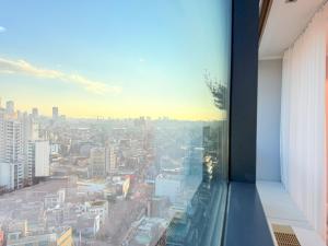 una ventana en un edificio con vistas a la ciudad en Oasis Hongdae City View, en Seúl