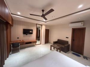 a living room with a ceiling fan and a couch at Hotel Rajiv Palace in Sāhibganj