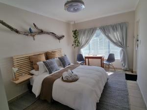 a bedroom with a large bed with a wooden headboard at Featherbed in Hermanus