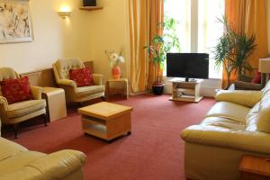 ein Wohnzimmer mit Sofas und einem Flachbildfernseher in der Unterkunft Hollybank - ensuite room & use of large shared kitchen in Dumfries