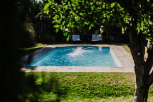 a swimming pool with two chairs in a yard at La Caballeriza Posada Boutique in San Rafael