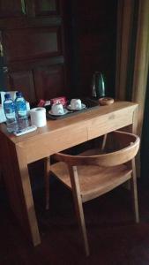 una mesa de madera con una silla y algunas botellas de agua en Villa Lalupa Joglo, en Canggu