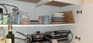 ブルーフケーベルにあるCasa Mia Russotto Zimmervermietungのキッチン(コンロ付)と棚に食器