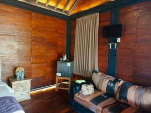 Una sala de estar con un sofá y un televisor. en Villa Lalupa Joglo, en Canggu