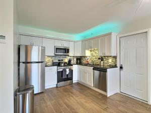 a kitchen with white cabinets and a stainless steel refrigerator at Crescent Beach 1011 #1 in Sarasota