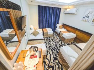 a hotel room with two beds and a television at فندق مكارم روز 1 Mkarem Rose Hotel in Makkah +4 photos