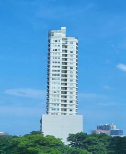 een hoog wit gebouw met bomen ervoor bij Modern Cozy with Netflix Condo Unit in Calyx Cebu Ayala in Cebu City +3 foto's